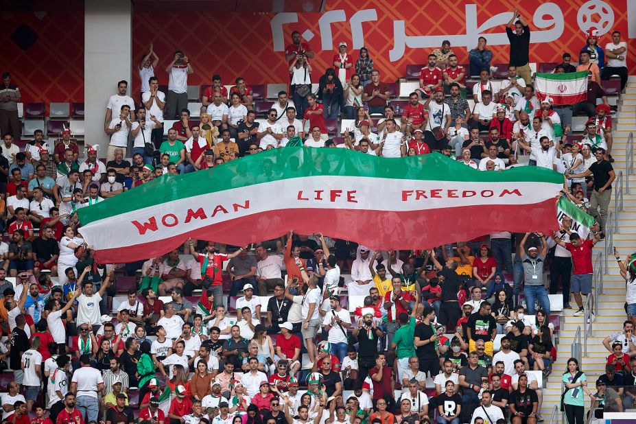 Iranian fans hold up a sign that reads "Woman Life Freedom" during the match against England. Anti-government protests have entered a third month back in Iran. Outside the stadium before the game, CNN witn