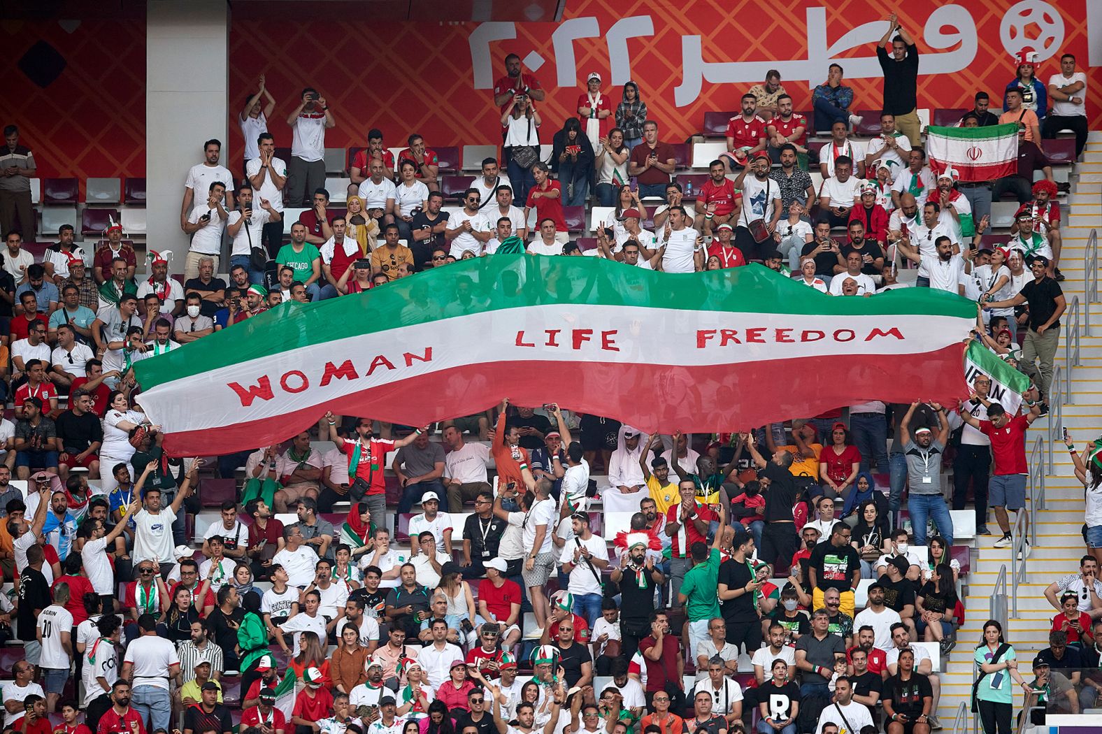 Iranian fans hold up a sign that reads "Woman Life Freedom" during the match against England. Anti-government protests have entered a third month back in Iran. Outside the stadium before the game, CNN witnessed a number of Iran supporters <a href="index.php?page=&url=https%3A%2F%2Fwww.cnn.com%2Fsport%2Flive-news%2Fworld-cup-11-21-22%2Fh_64af1374bbf15fe3487b65c05d1b99b1" target="_blank">wearing protest T-shirts</a>, with slogans such as "Free Iran" or "Rise with the women of Iran."