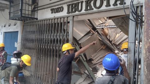 Workers inspect a store shaken by an earthquake in Cianjur, West Java, Indonesia. The quake killed scores of people, damaged dozens of buildings and sent residents into the streets for safety.