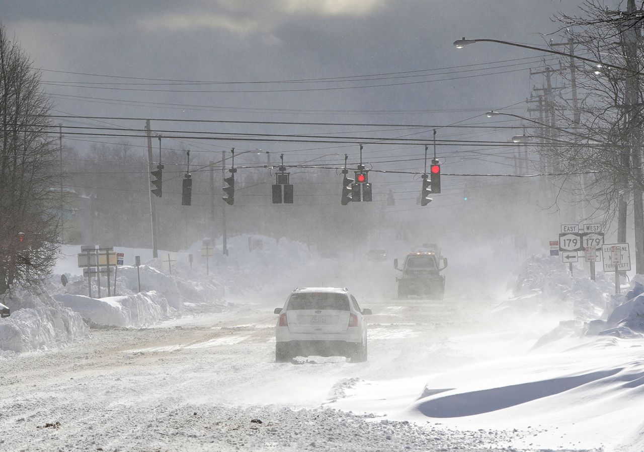 Cars drive through blowing, drifting snow on McKinley Parkway in Hamburg in Erie County on Sunday.