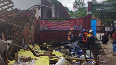 Workers inspect a school damaged by the earthquake in Chanjul, West Java.