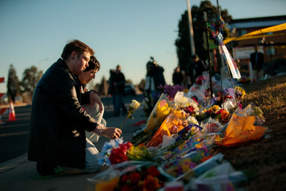 Ren Kurgis, left, and Jessie Pacheco leave flowers Sunday at the growing memorial in Colorado Springs.