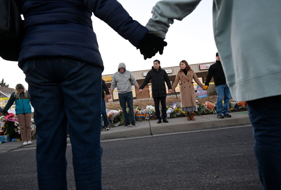 People link hands at the memorial near Club Q in Colorado Springs.