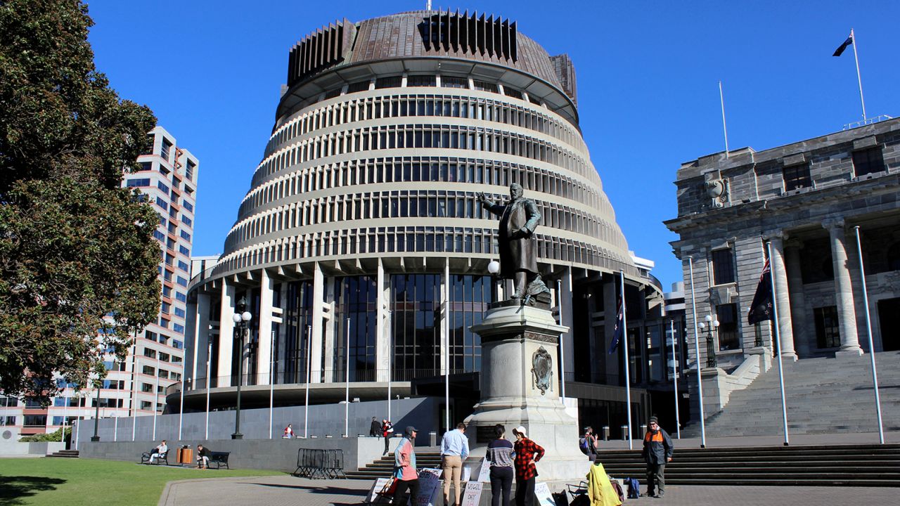 People stand outside the executive wing of the New Zealand Parliament complex. 