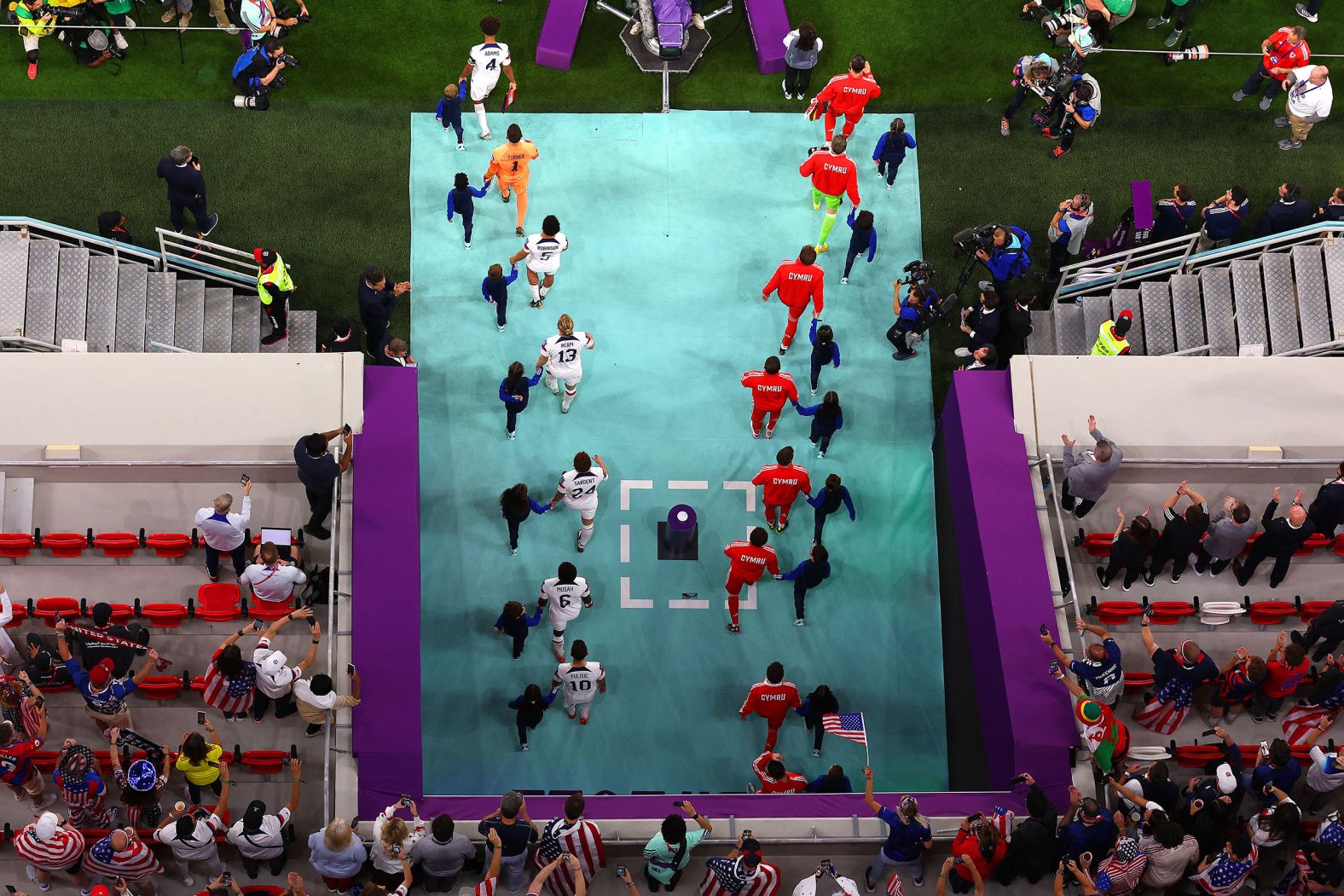 Welsh and American players walk onto the field.