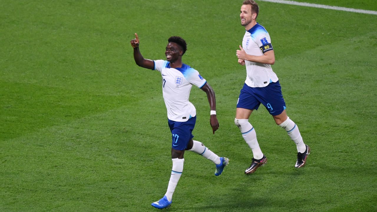 Saka (left) celebrates England's fourth goal against Iran.