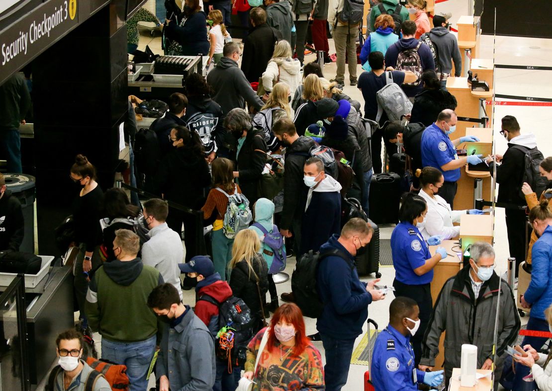 Travelers wait at a security checkpoint at Seattle-Tacoma International Airport on November 24, 2021. Holiday air travel is up this year.