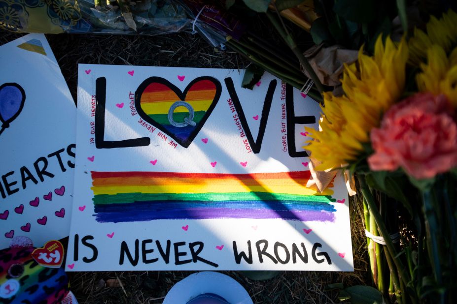 Signs and flowers are placed at a memorial outside of Club Q in Colorado Springs.