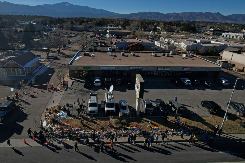 People visit a makeshift memorial Monday on a corner near the site of the mass shooting.