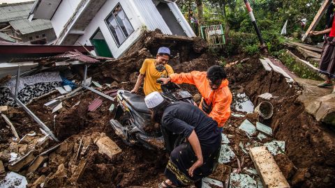 Warga mengambil barang-barang dari rumah yang rusak setelah gempa bermagnitudo 5,6 di Cianjur pada 22 November 2022. 