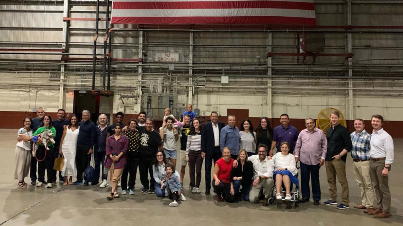 A group of seven Americans are pictured with their families and officials upon returning to the United States after being detained in Venezuela.