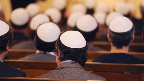 People sit inside a synagogue.