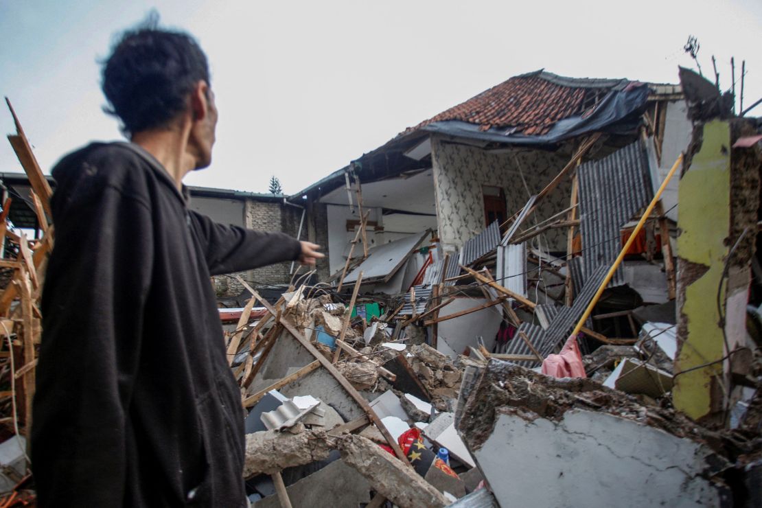 A man stands near houses damaged after earthquake hit in Cianjur, West Java province, Indonesia, November 21, 2022.