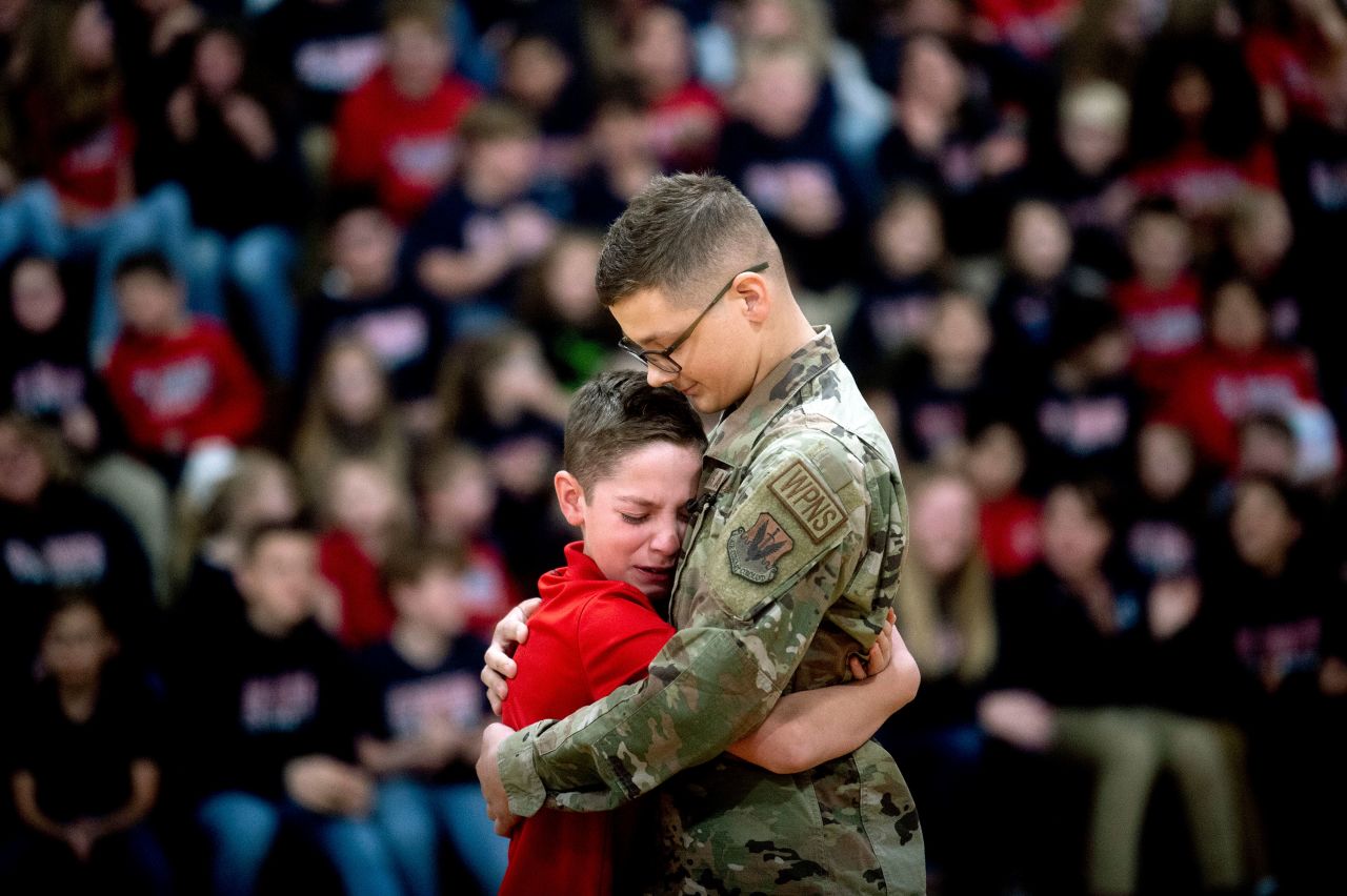 Easton Gunsell, 11, cries after rushing into his brother Braden Locker's arms for a hug in Flushing, Michigan, on Tuesday, November 22. Locker, a 20-year-old airman stationed in Saudi Arabia, was home on leave and surprised his brother at school.