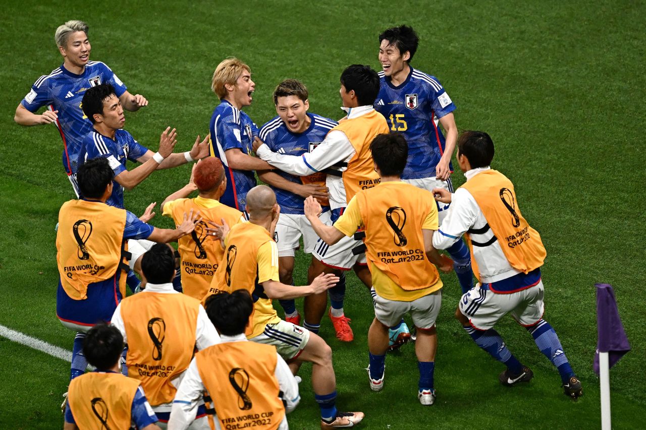 Japan midfielder Ritsu Doan, center, is mobbed by teammates after scoring the team's first goal against Germany on Wednesday. Japan went on to win 2-1.