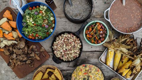 A spread of foods including fire roasted pig, sweet potatoes, hominy and mush, prepared by Barton and fellow chefs Nico Albert and Brad Dry.