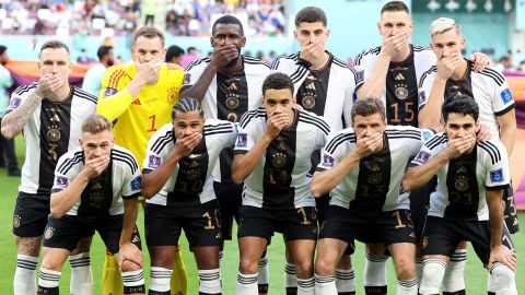 Немецкие игроки позируют, закрыв рот руками перед матчем чемпионата мира против Японии.