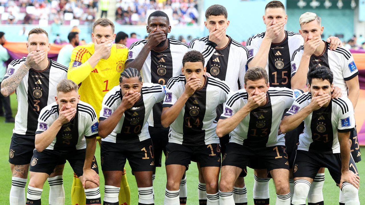 Germany's players pose with their hands covering their mouths prior to their World Cup game against Japan.
