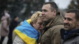 A woman leans on Ukrainian lawmaker and officer Roman Kostenko as they celebrate the recapturing in Kherson, Ukraine, Saturday, Nov. 12, 2022. People across Ukraine awoke from a night of jubilant celebrating after the Kremlin announced its troops had withdrawn to the other side of the Dnieper River from Kherson. The Ukrainian military said it was overseeing "stabilization measures" around the city to make sure it was safe.