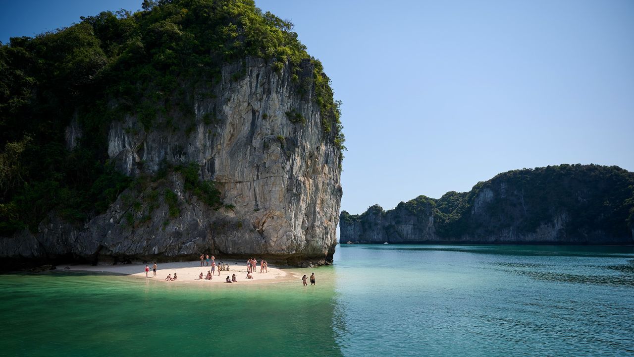Lan Ha Bay, Cat Ba Island, Vietnam - February 26, 2020: Tourists rest on the beach, break during the cruise on Lan Ha Bay in Vietnam