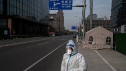 An epidemic control worker wears protective clothing to protect against the spread of COVID-19 as she stands in a nearly empty street in the Central Business District on November 23, 2022 in Beijing, China. 