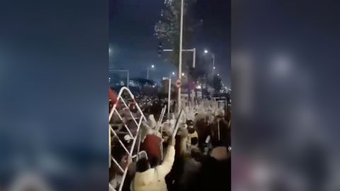 Workers throw parts of the metal barriers they have torn down at the police.