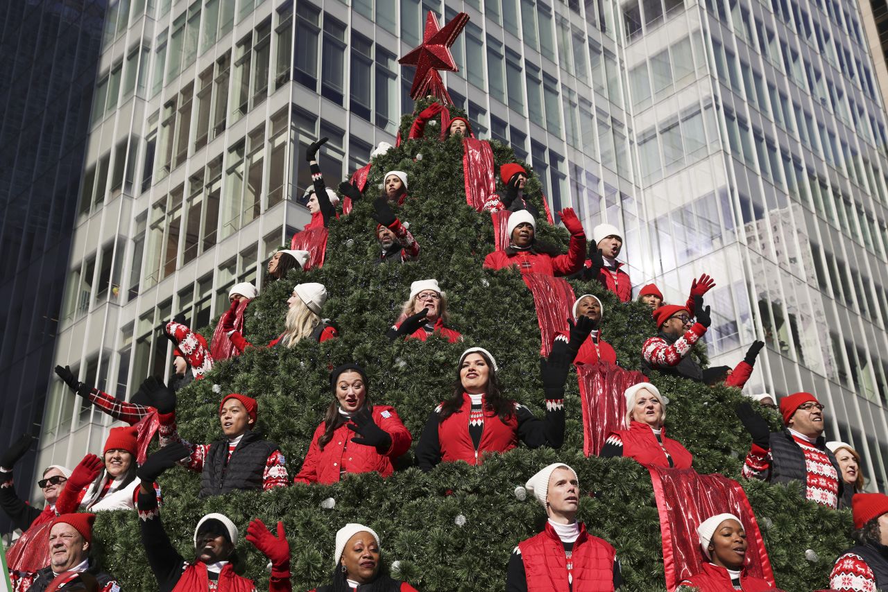 Performers on the Macy's Singing Christmas Tree float wave to spectators on Thursday.