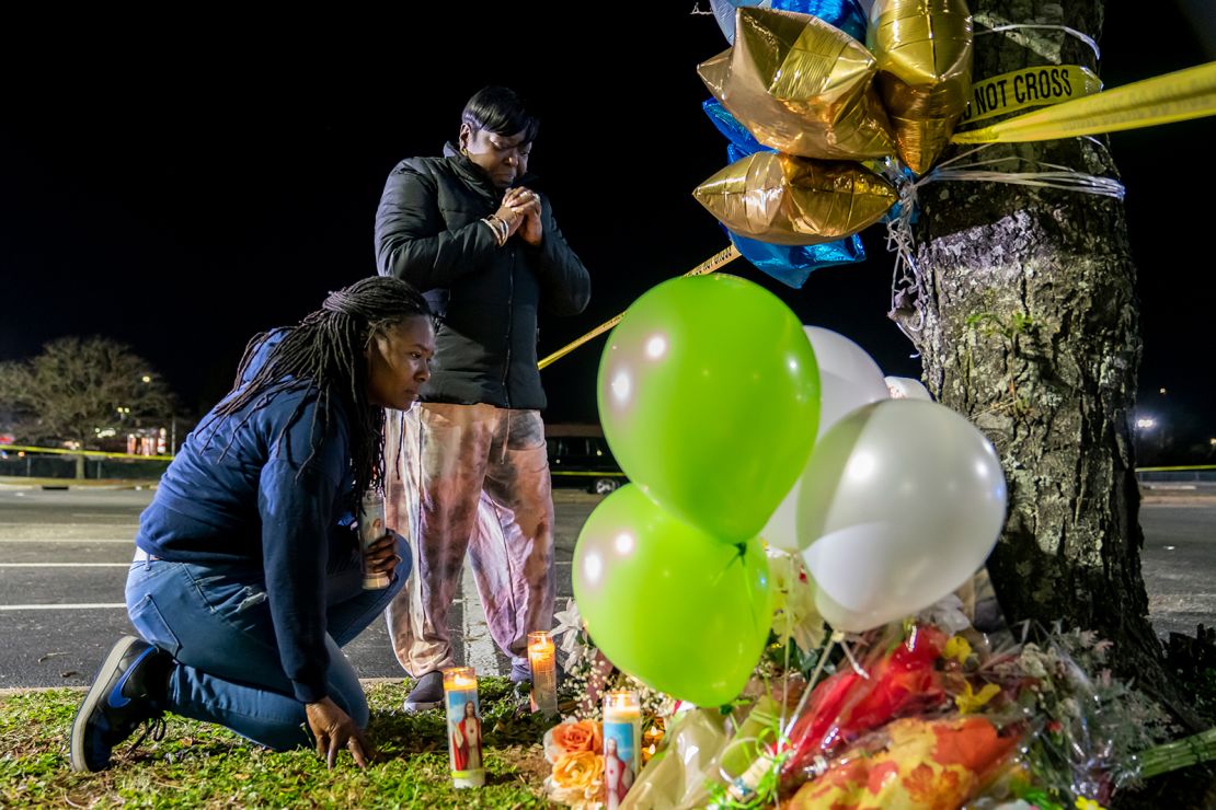 Lashana Hicks (left) joins other mourners Wednesday at a memorial for those killed in a mass shooting at a Walmart Supercenter in Chesapeake, Virginia.