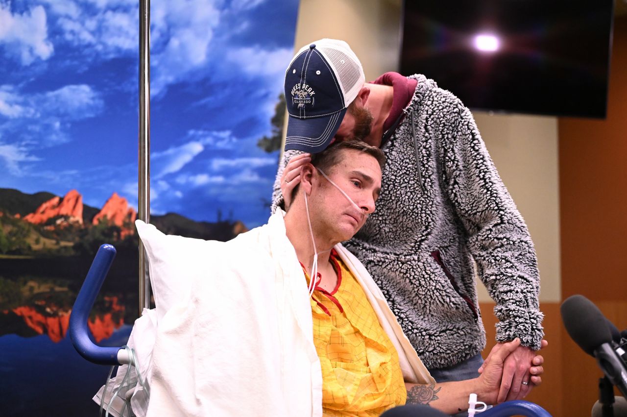 Jeremy, right, comforts his partner, Anthony, at a hospital in Colorado Springs, Colorado, on Tuesday, November 22. Anthony was injured in the nightclub shooting over the weekend.