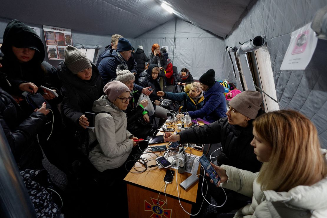 Local residents charge their devices, use internet connection and warm up inside a shelter in Kyiv on November 24, 2022.