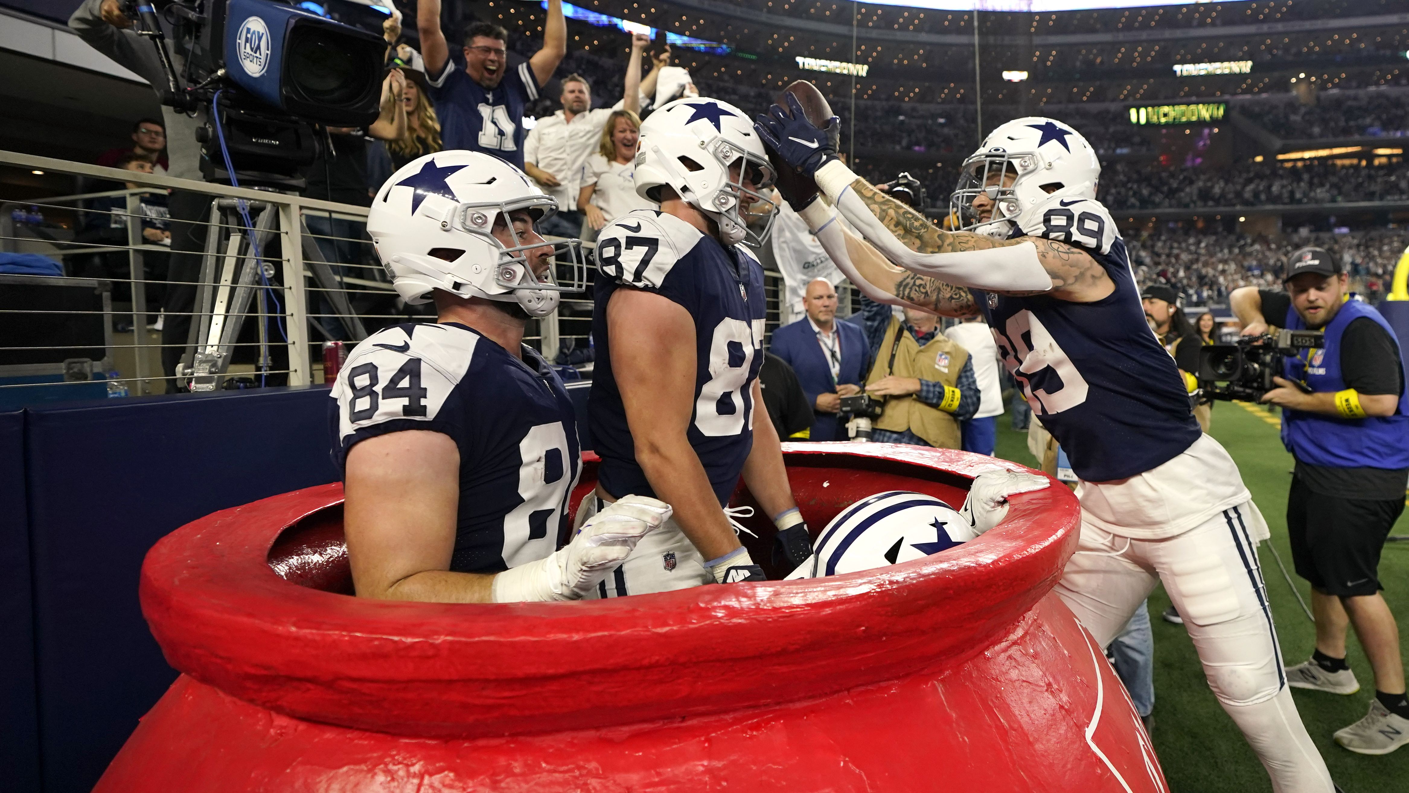 Dallas' Peyton Hendershot, right, celebrates a touchdown with teammates inside a big Salvation Army kettle during the Cowboys' Thanksgiving Day win over the New York Giants on Thursday, November 24.