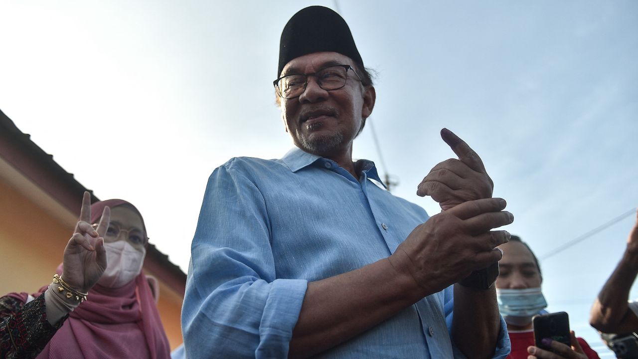 Malaysia's leader Anwar Ibrahim, chairman of the Pakatan Harapan (Alliance of Hope), shows his inked finger after voting at a polling station during the general election in Permatang Pauh, Malaysia's Penang state, on November 19, 2022. 