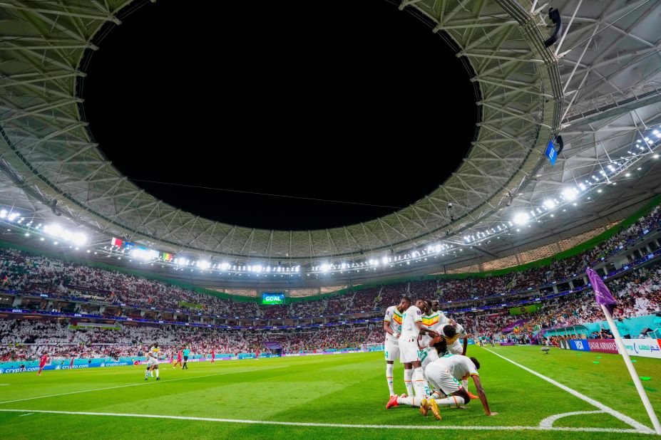 Senegal players celebrate at the corner flag after Bamba Dieng scored the third goal in their 3-1 victory over host nation Qatar.