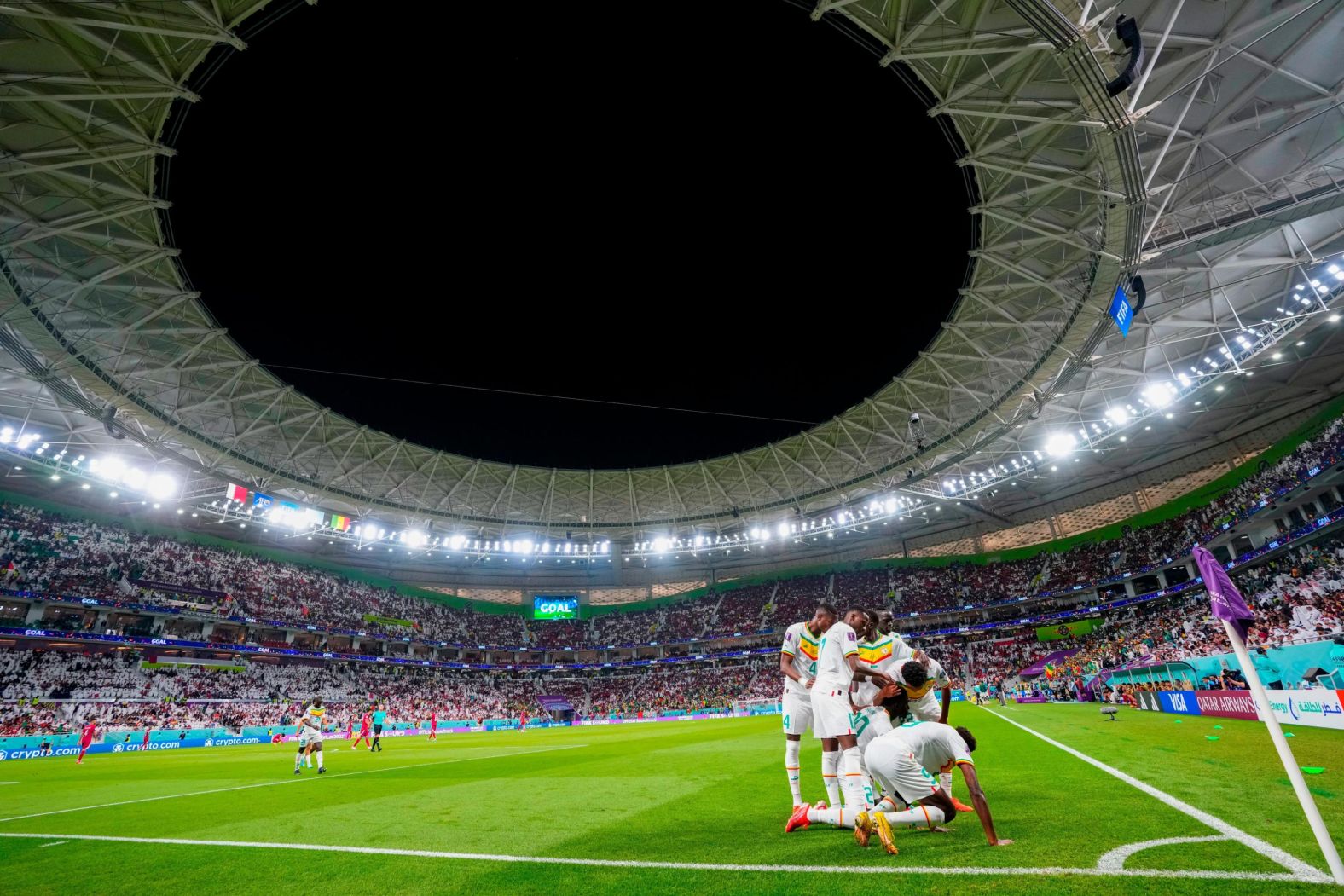 Senegal players celebrate at the corner flag after Bamba Dieng scored the third goal in their 3-1 victory over host nation Qatar.