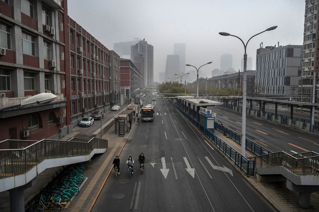 People ride bikes on an empty street near Beijing's central business district on November 24. 