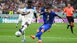AL KHOR, QATAR - NOVEMBER 25: Christian Pulisic of United States shoots the ball off the crossbar against Bukayo Saka of England during the FIFA World Cup Qatar 2022 Group B match between England and USA at Al Bayt Stadium on November 25, 2022 in Al Khor, Qatar. (Photo by Clive Mason/Getty Images)