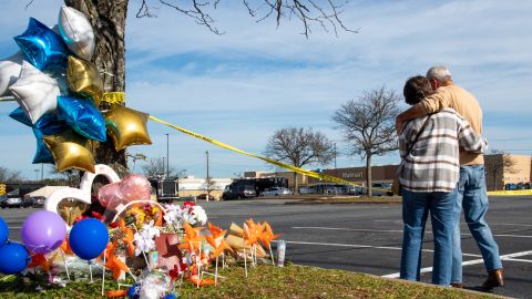 Chet Barnett, right, and his wife, Debbie, hug and stand in a moment of silence in the parking lot of Walmart in Chesapeake, Virginia, on November 24.