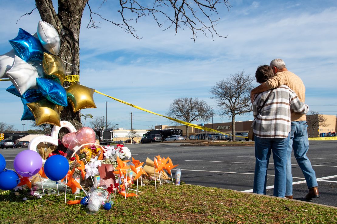 Chet Barnett, right, and his wife, Debbie, hug and stand in a moment of silence in the parking lot of Walmart in Chesapeake, Virginia, on November 24.