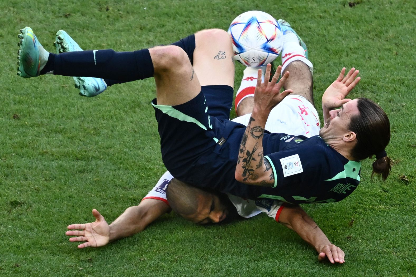 Australia's Jackson Irvine falls on Tunisia's Aissa Laidouni as they battle for the ball on November 26. Australia won 1-0.