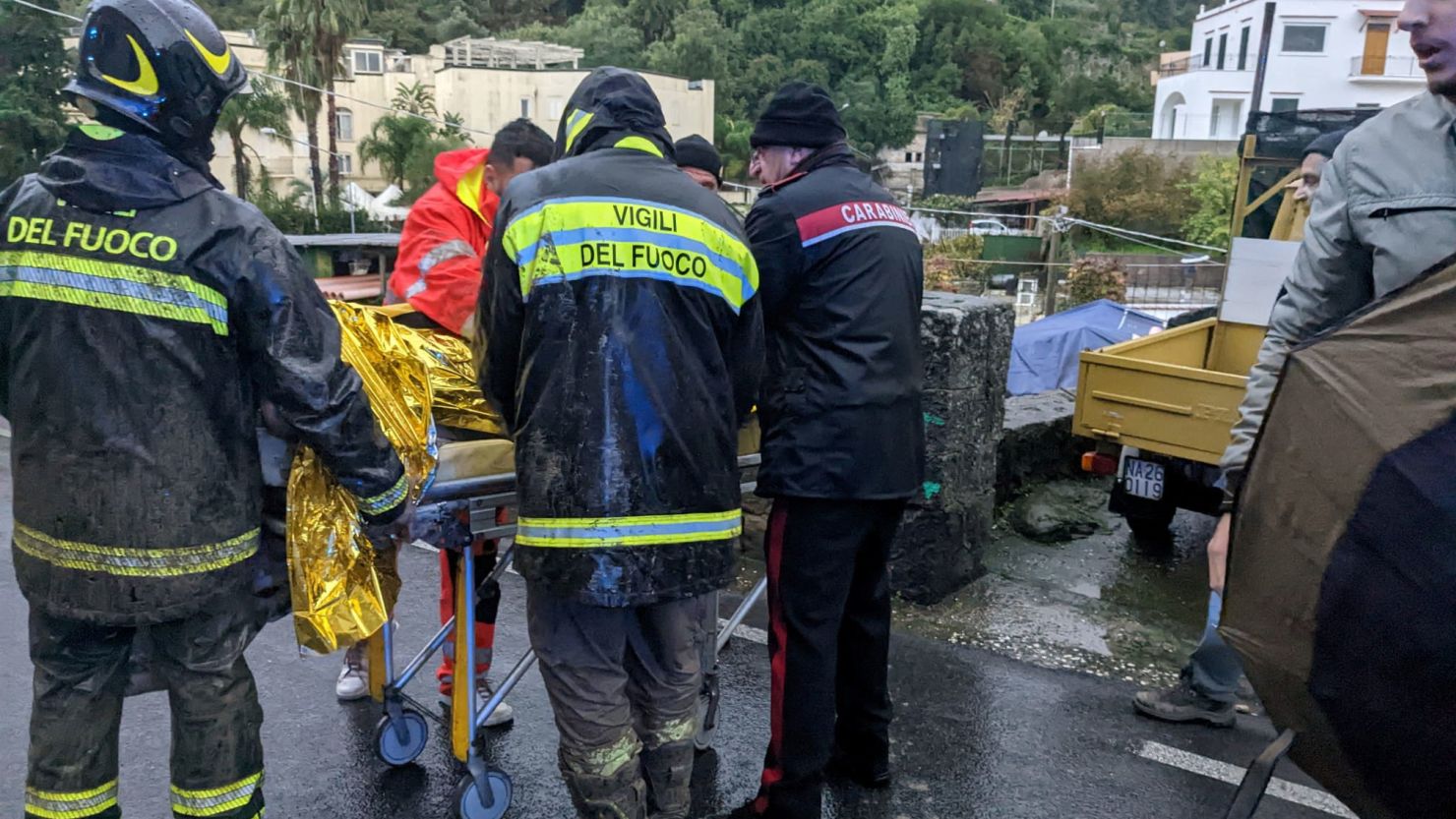 Rescuers help an injured person following a landslide on the Italian holiday island of Ischia, Italy, on November 26, 2022. 