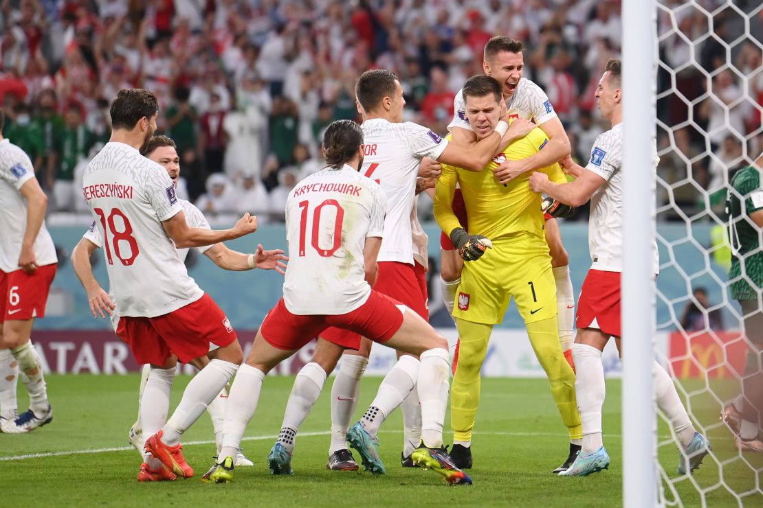 Wojciech Szczesny celebrates with his teammates after saving a penalty and rebound.