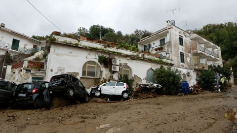 Carros danificados caídos na rua após o deslizamento de terra no sábado.