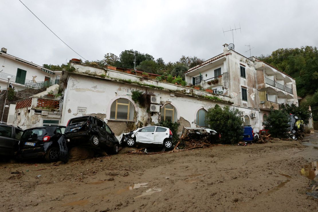 Damaged cars lie on the street following Saturday's landslide.