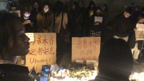 I manifestanti stanno accanto ai cartelli di protesta a Shanghai, in Cina, sabato 26 novembre 2022.