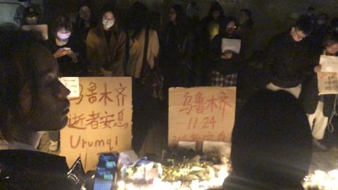 Demonstrators stand by protest signs in Shanghai, China, on Saturday, Nov. 26, 2022. 