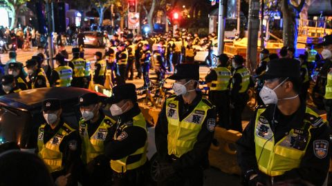 Police officers block off Urumqi Road in Shanghai on Sunday.