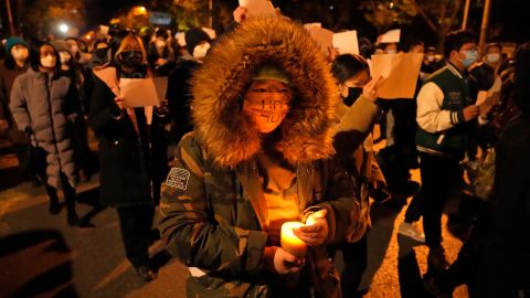 A Beijing protester holds a candal in demonstrations on Sunday night.