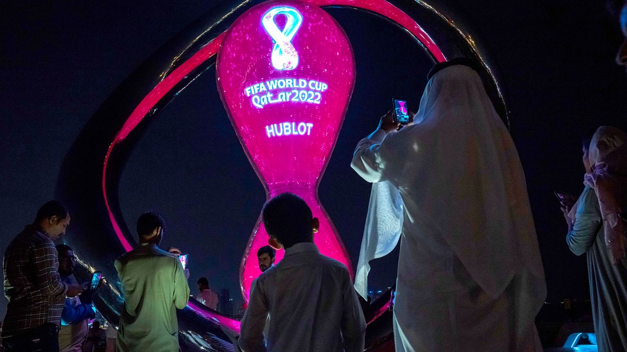 People take photos with the official FIFA World Cup Countdown Clock on Doha's corniche, in Qatar, on October 14.