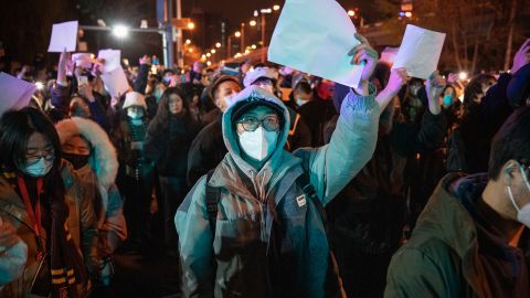 Demonstrators hold up blank sheets of paper during a protest in Beijing on November 28.