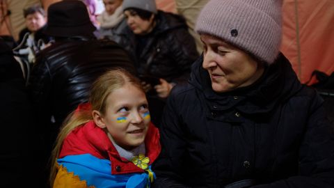 Hanna, right, and her daughter Nastya sit together in the tent charging the phone.